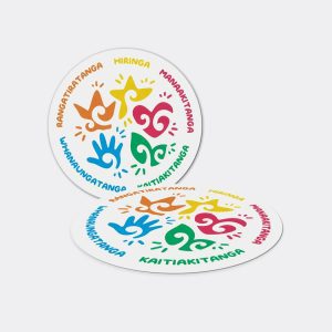 a white round coaster with colorful designs